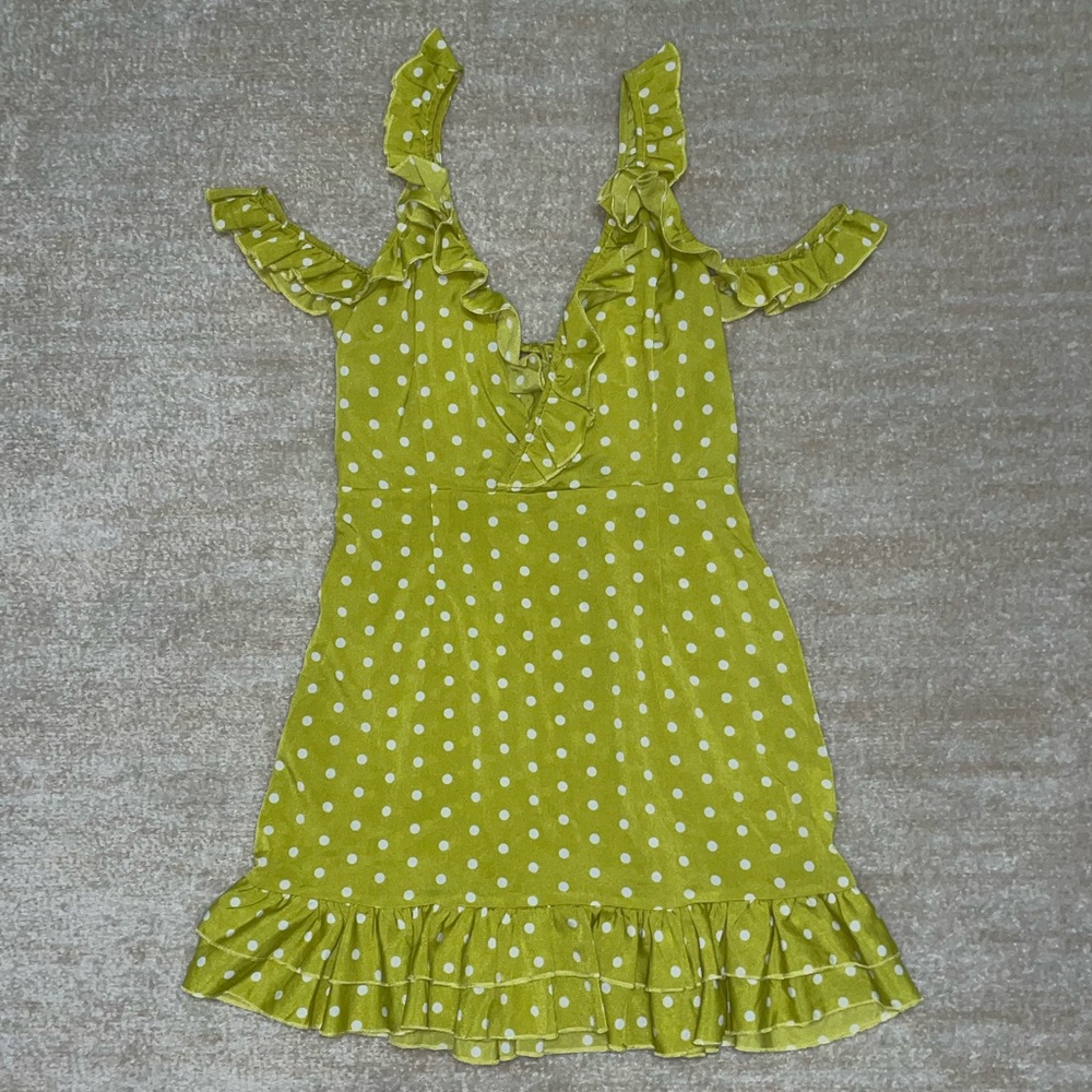 Lime green polka-dot, mini dress with frill details and shoulder cutouts.